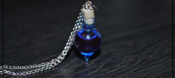 A blue potion inside a small vial, with a steel chain trailing off to the left.